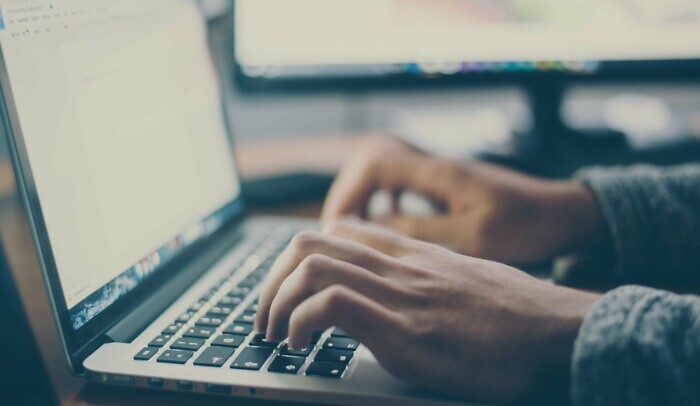 Händer skriver på laptop
