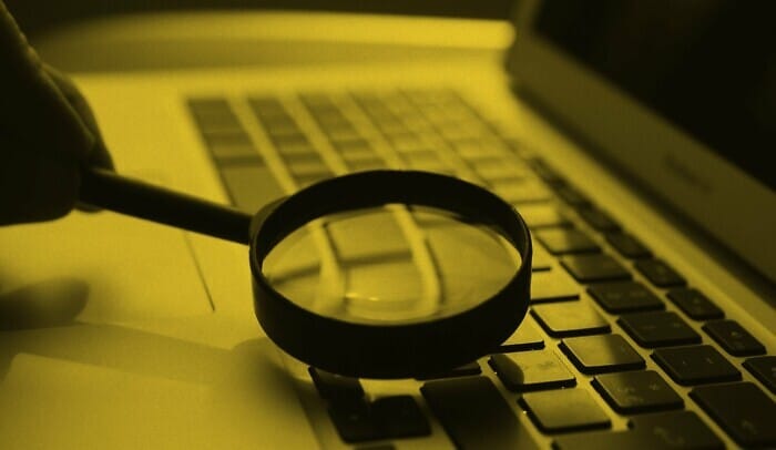 Förstoringsglas ligger på laptop