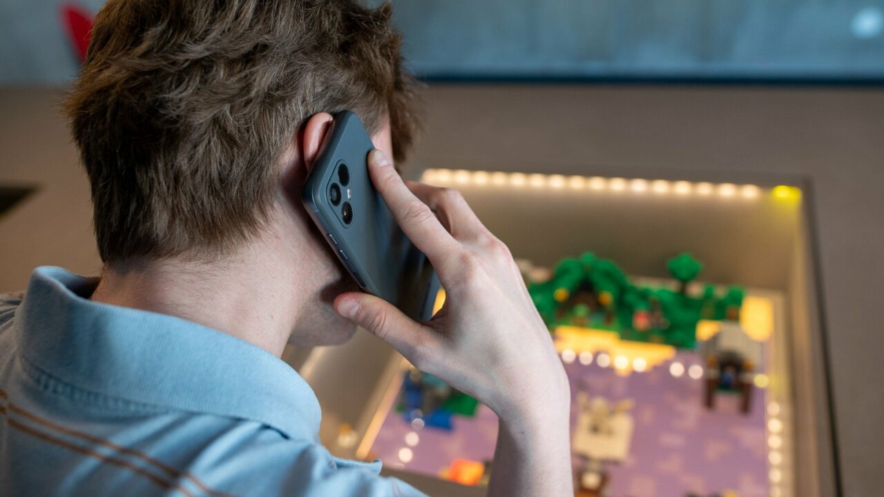 En man syns bakifrån, han pratar i mobiltelefonen.