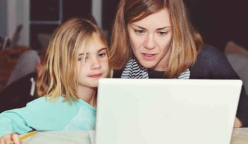 Mamma och dotter tittar tillsammans på en laptop