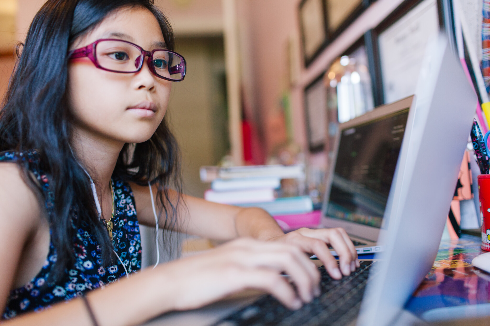Flicka sitter framför en laptop och skriver på tangentbord. Internetkunskap
