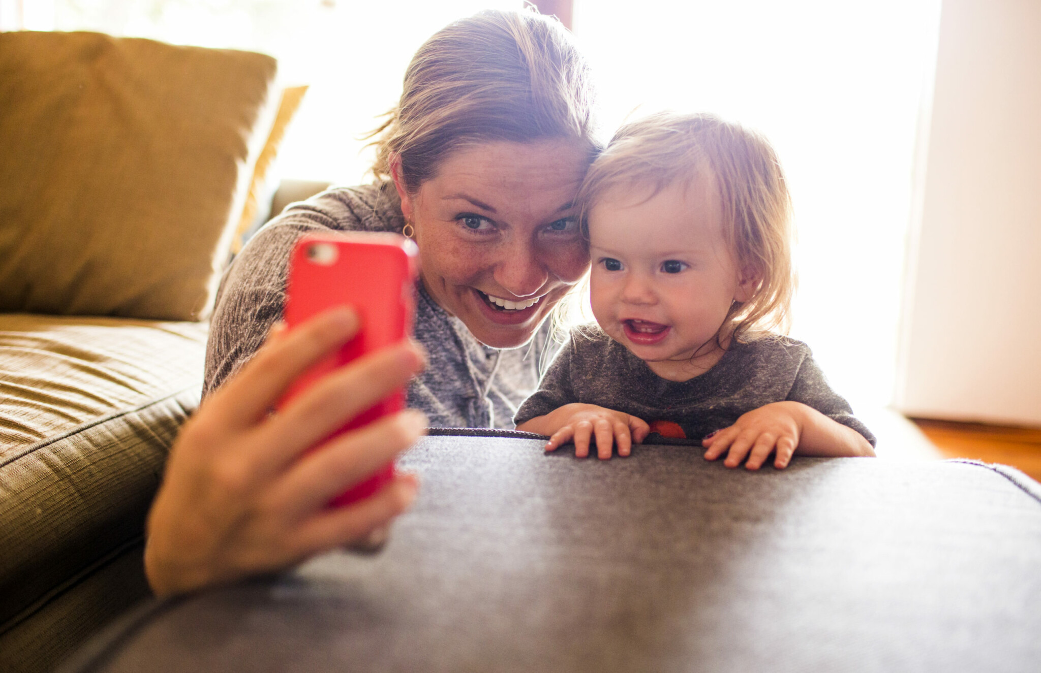Kvinna och bebis tar en selfie med mobiltelefon.