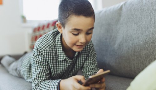 Ett barn kollar på en mobiltelefon