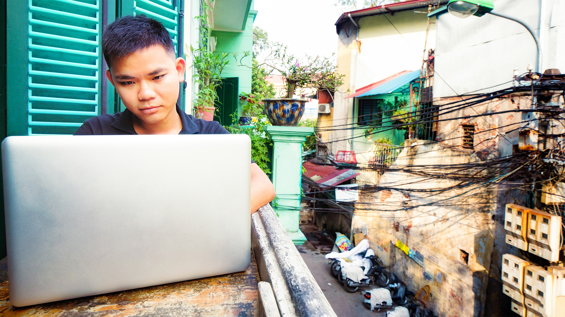 Kille från Asien som sitter i fönster och surfar på sin dator. internet mänsklig rättighet