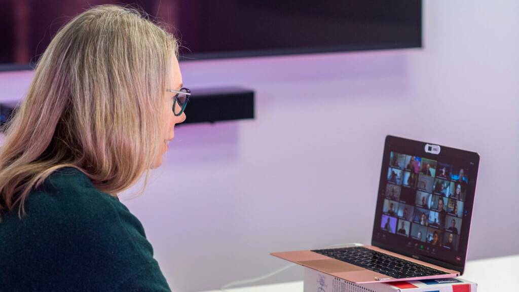 En kvinna sitter framför en laptop och har ett videomöte.