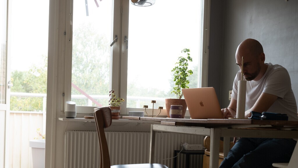 En man sitter vid ett bord och använder Darknet.