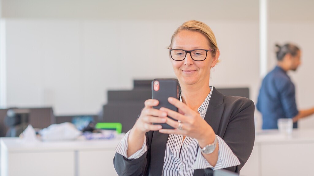 En kvinna låser upp sin mobil med ansiktsigenkänning.