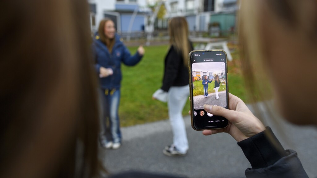 En kvinna som fotograferar en grupp människor.
