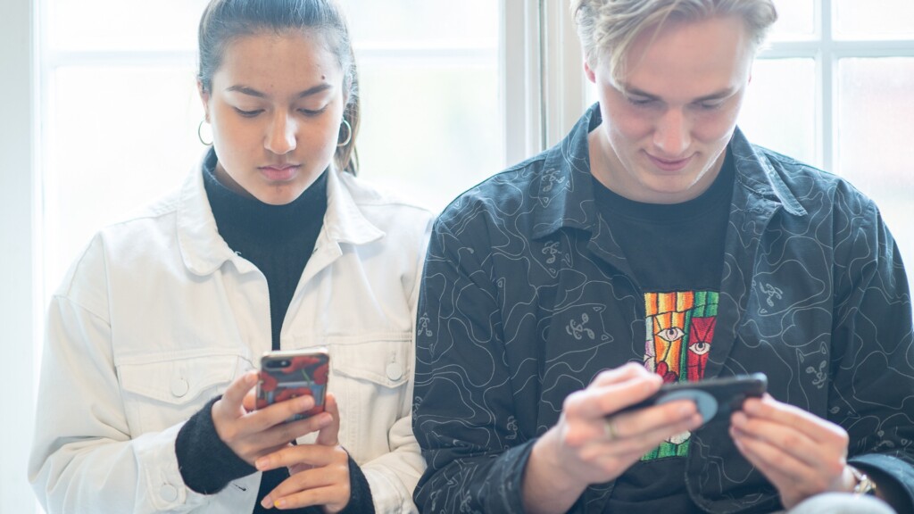 Gymnasiebarn använder mobiltelefon.